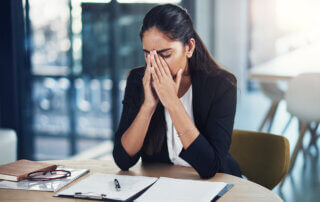 Image of women with hands over her nose with distressed look on her face